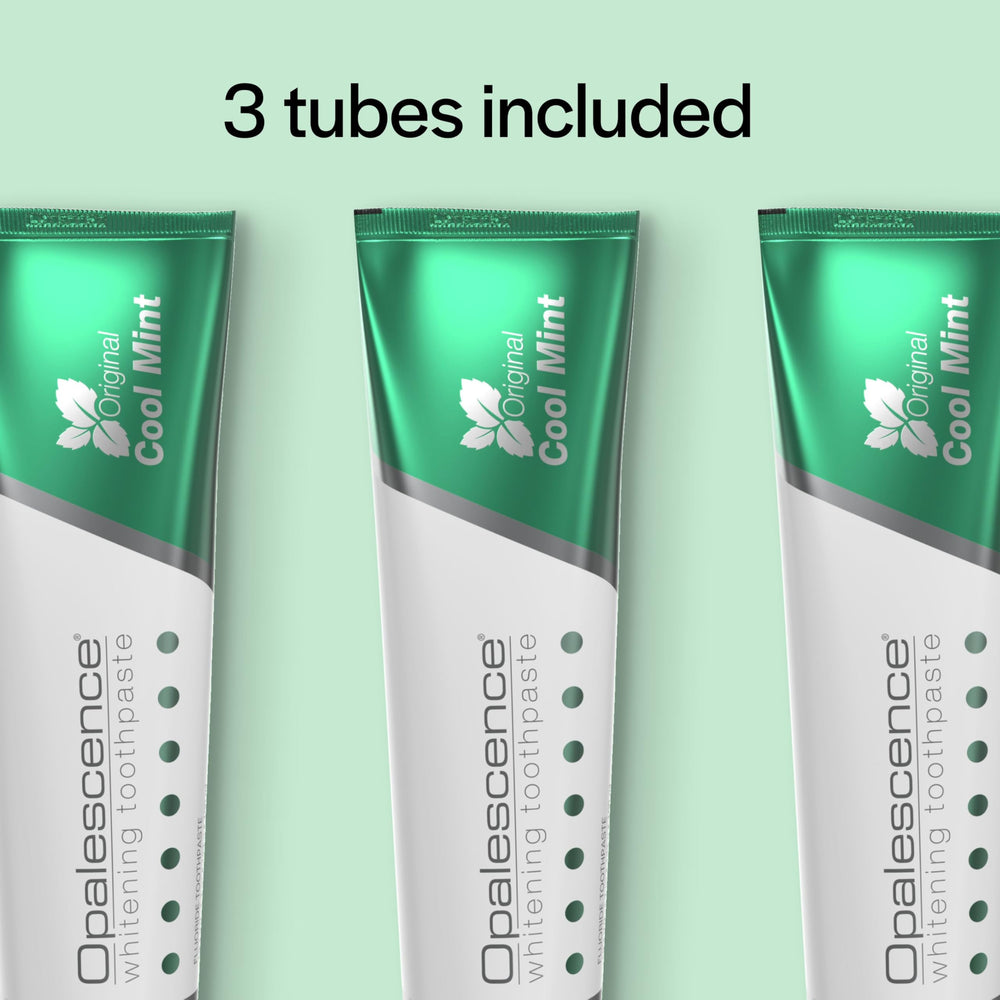 Opalescence tubo sostenido en mano para comparar tamaño y duración del producto