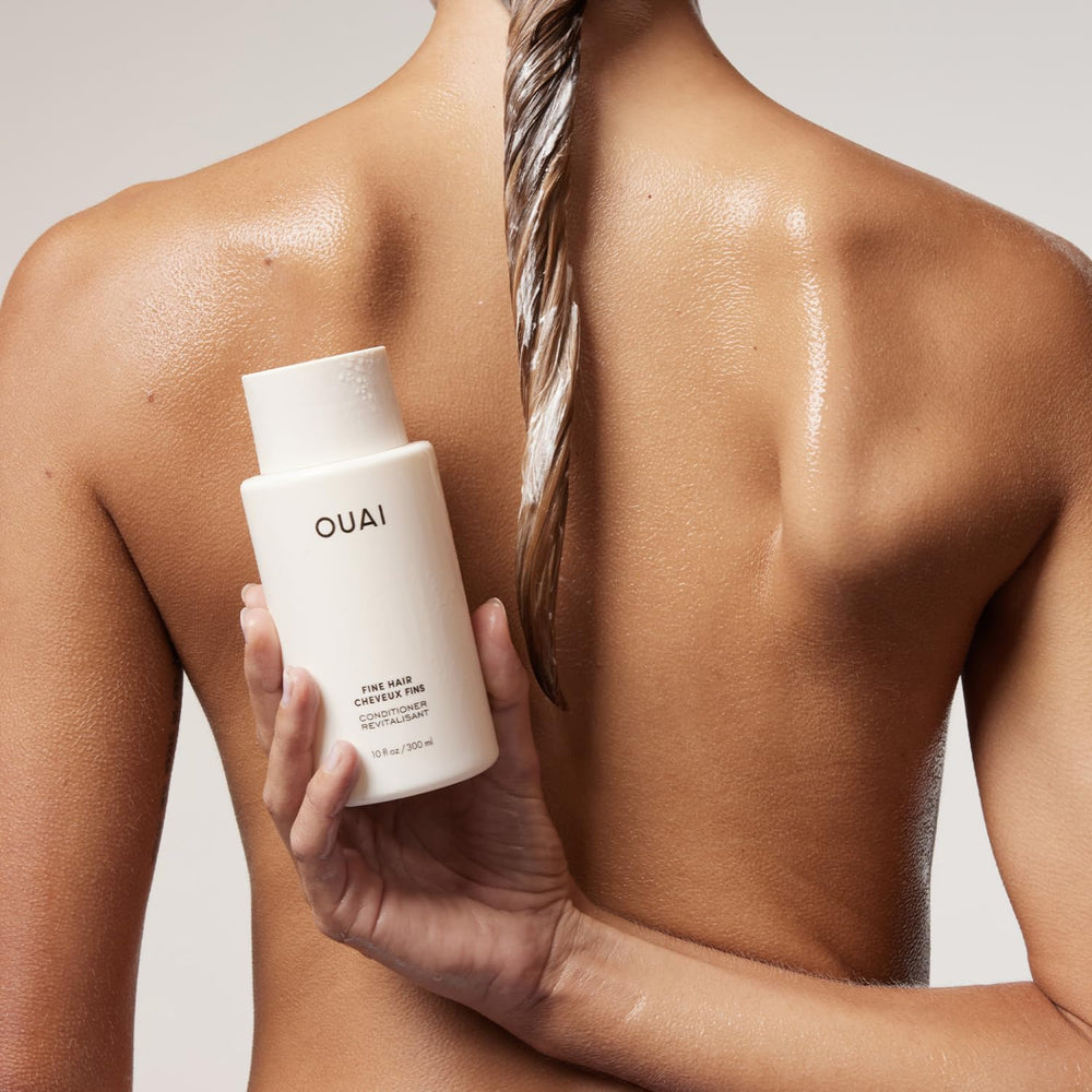 OUAI envase 10 oz en mano para comparar tamaño práctico