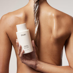 OUAI envase 10 oz en mano para comparar tamaño práctico