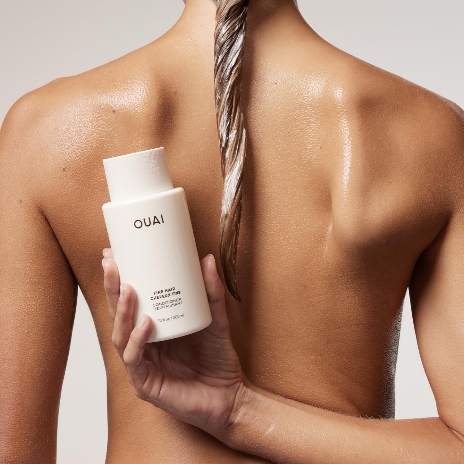 OUAI acondicionador en uso en la ducha mostrando aplicación fácil y resultados suaves