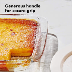 OXO hands lifting dish from oven using wide handles for secure grip