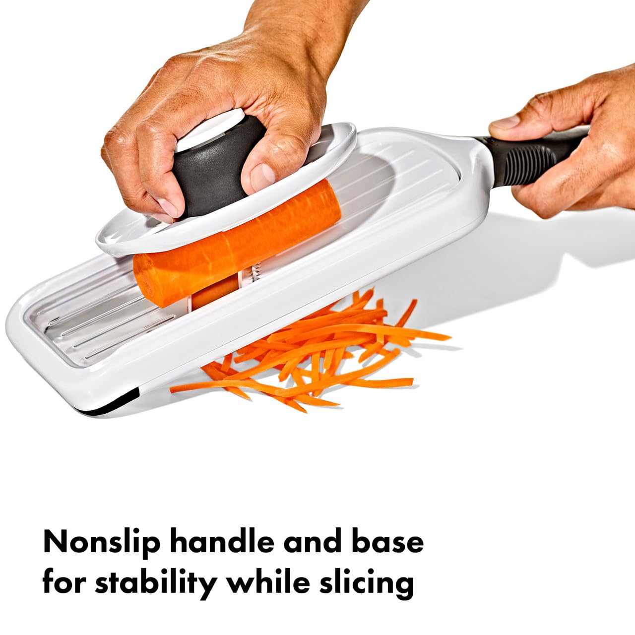 OXO mandolina junto a manos para comparar tamaño y ergonomía