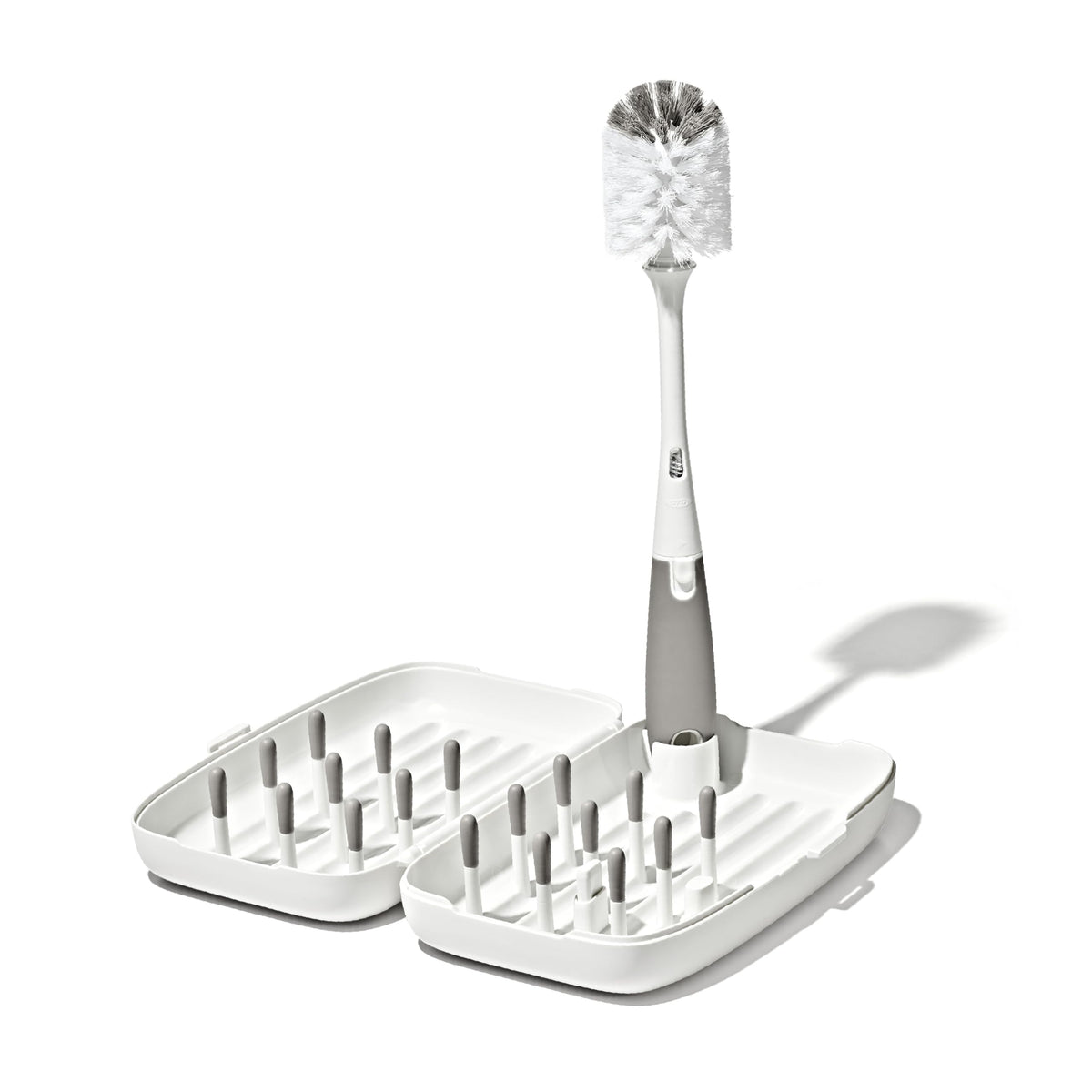 OXO Tot front view of compact travel drying rack showing organized bottles and pegs