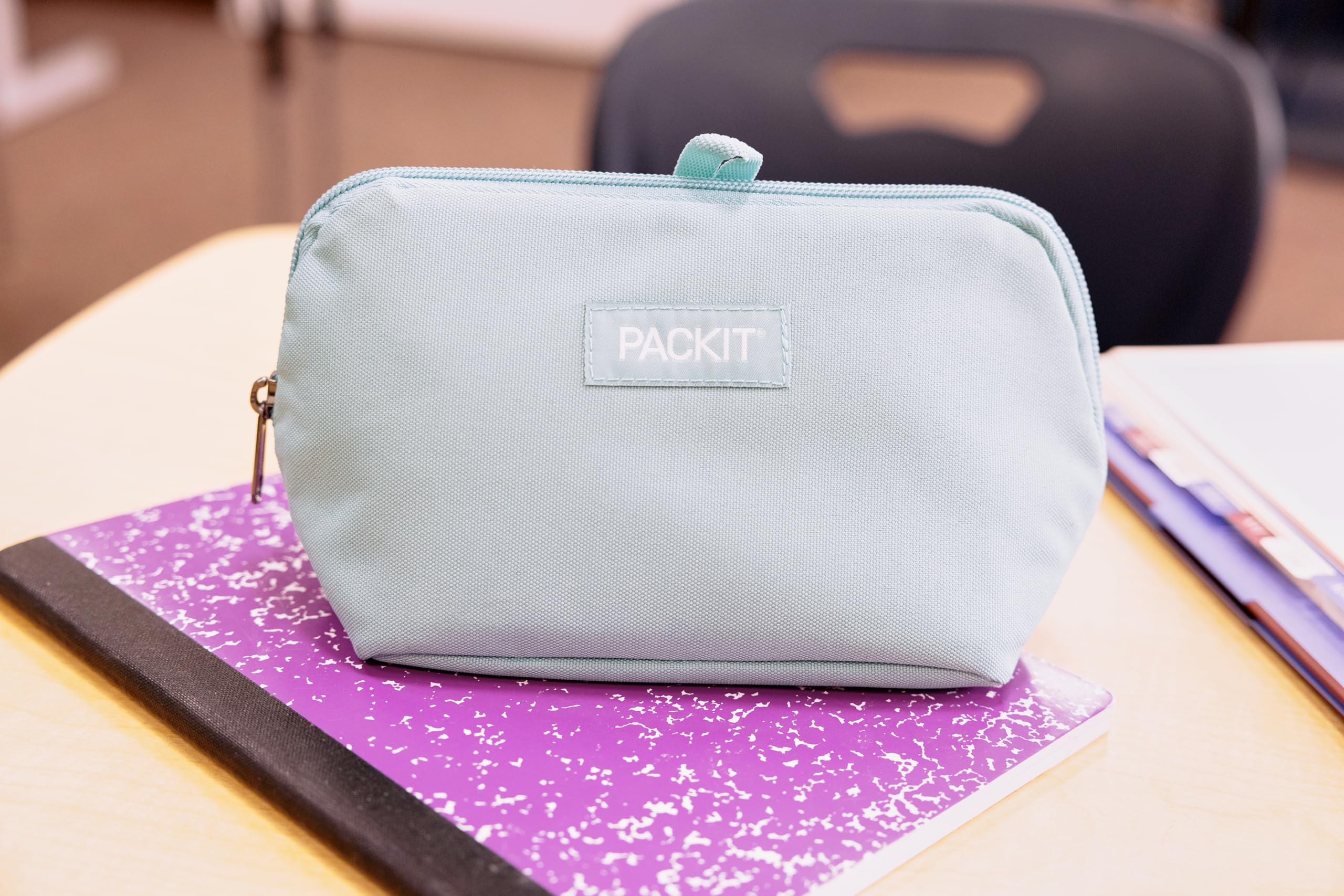 PackIt junto a una mano y objeto para comparar tamaño práctico