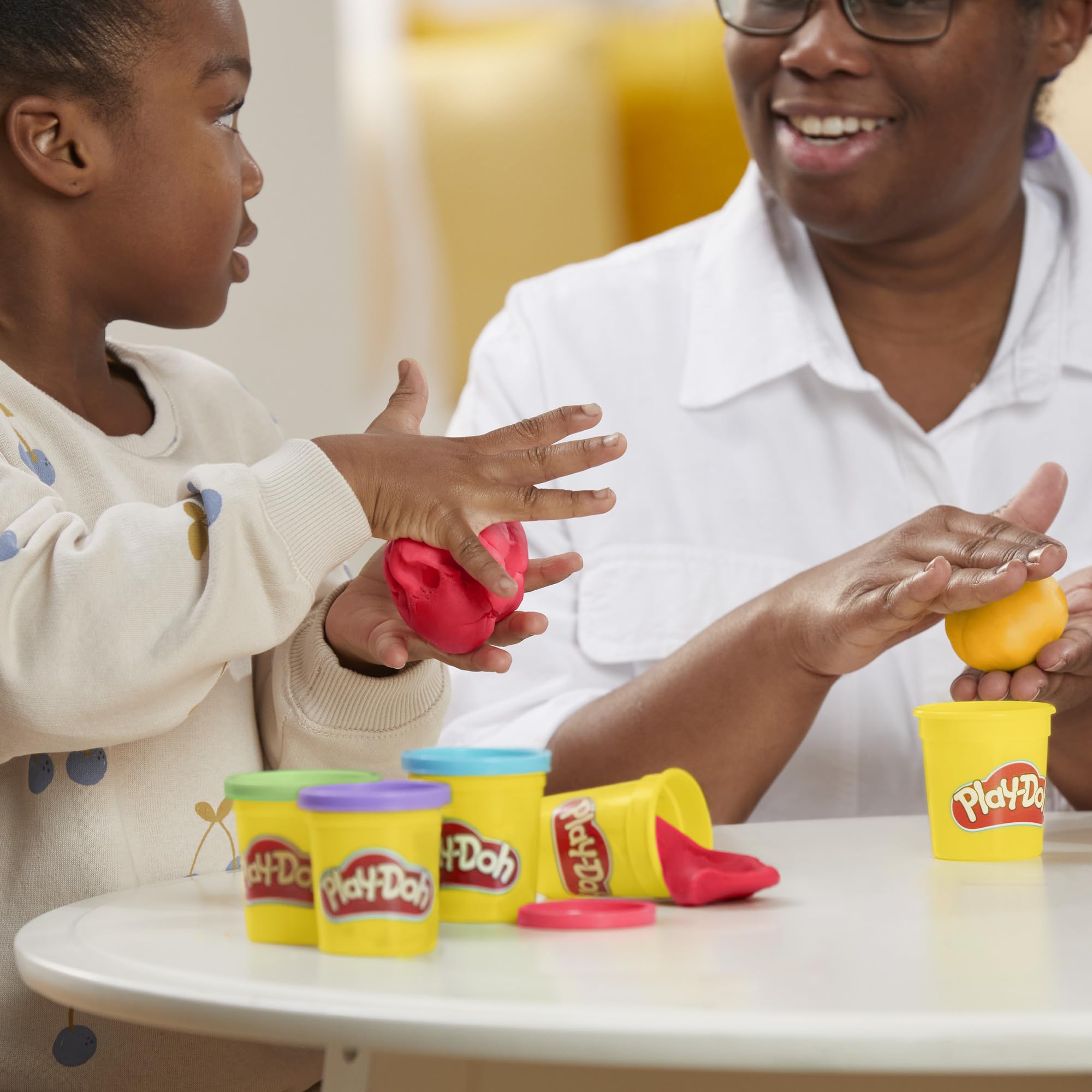 Play‑Doh comparación de tamaño con manos para ver escala de los botes