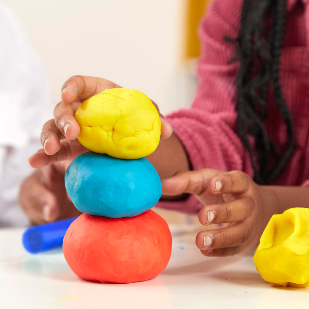 Play‑Doh 1‑ounce can beside coin for size comparison and portion clarity