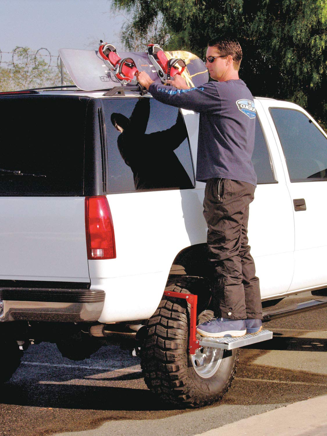 Escalón Powerbuilt junto a una bota para comparar tamaño y mostrar portabilidad