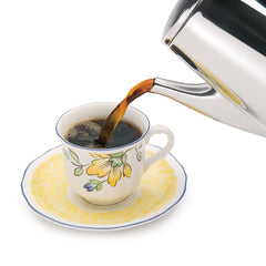 Presto al lado de una taza y una libreta para comparar tamaño y capacidad compacta