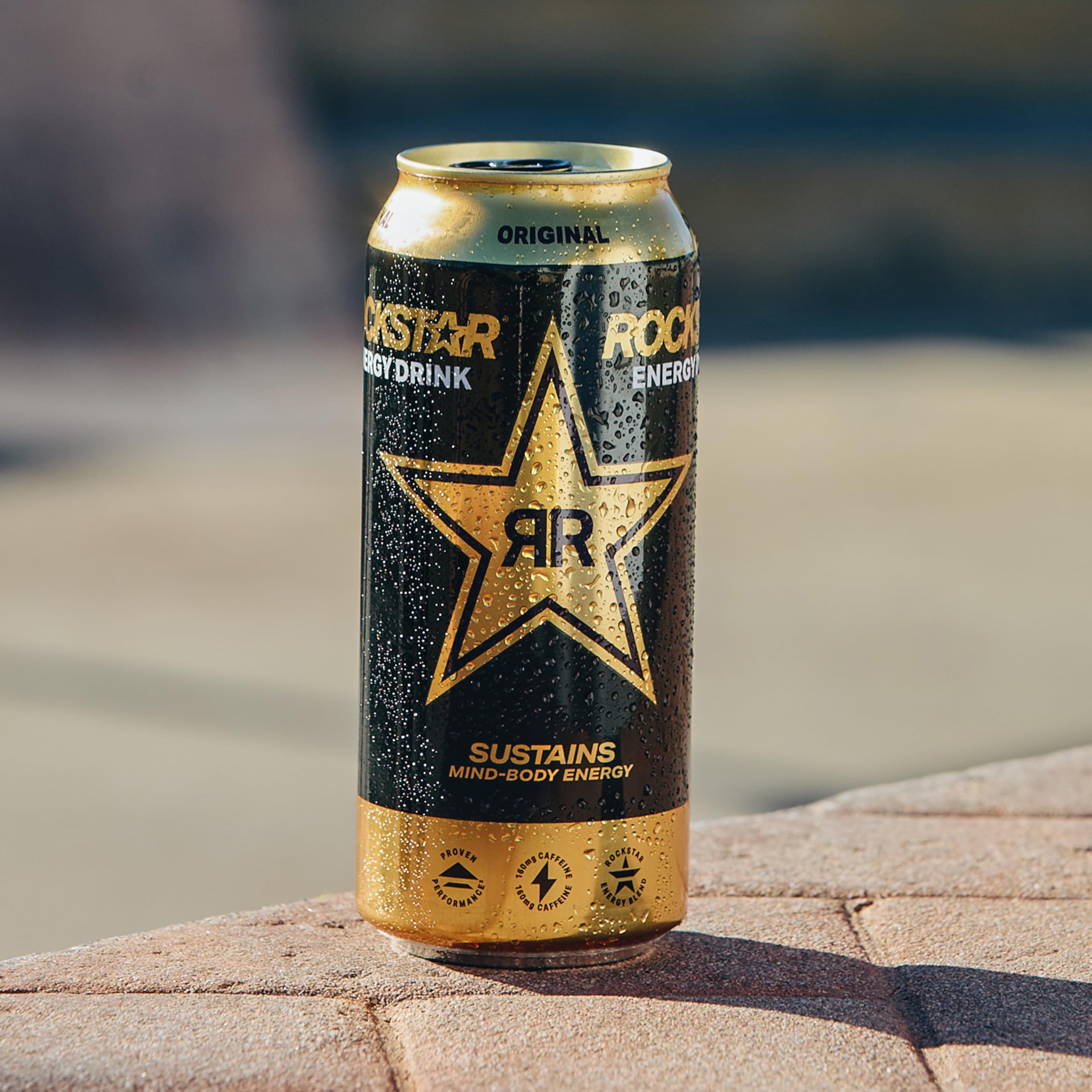 Rockstar original can beside smartphone showing 16 fl oz size comparison