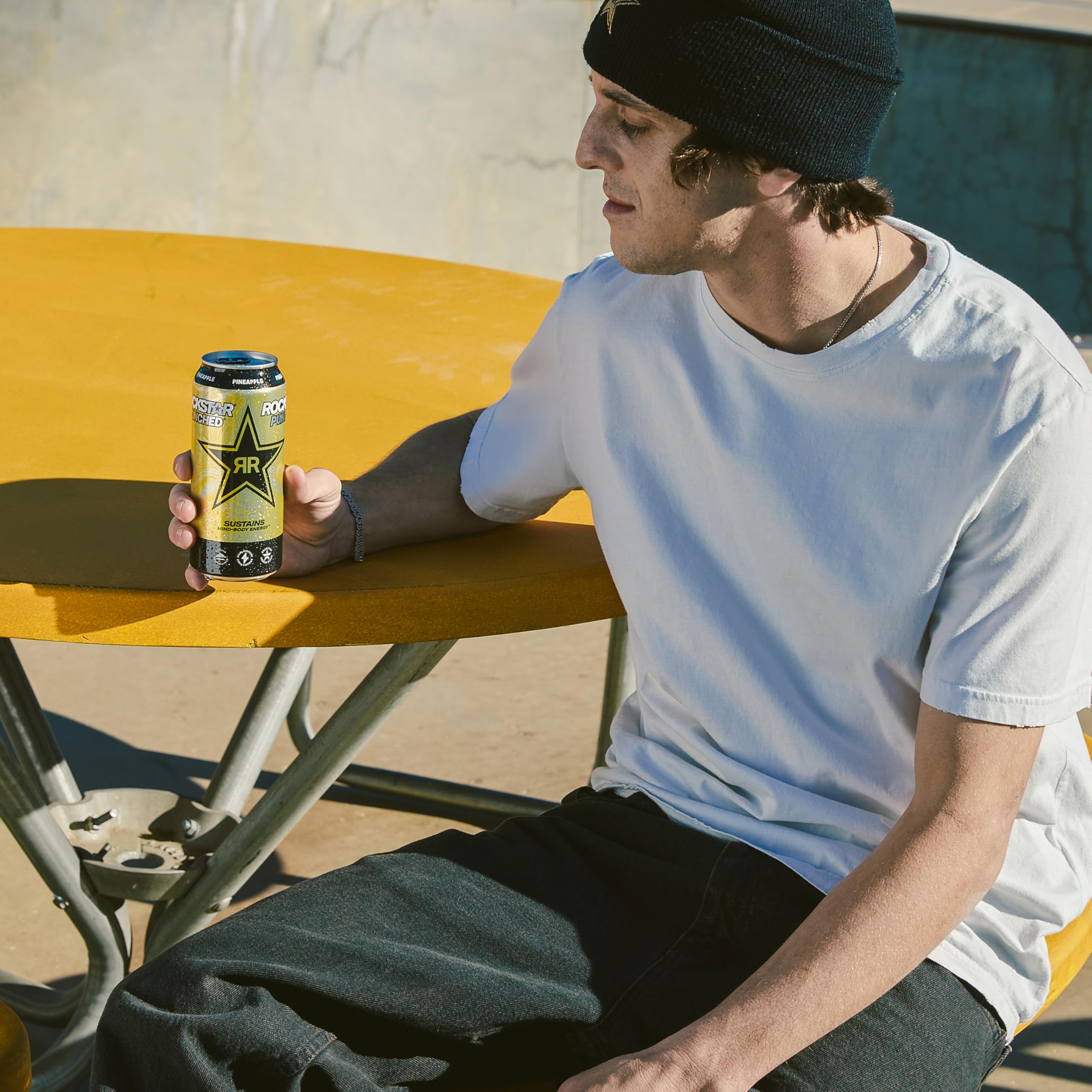 Rockstar lata junto a mano para comparar tamaño y porción
