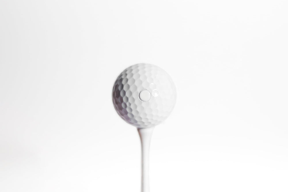 SHOCK'D GOLF BALLS sobre pasto simulando el momento de impacto