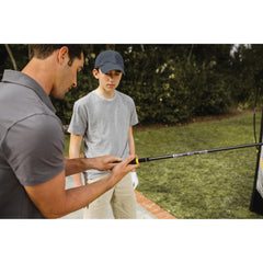 SKLZ jugador usando el entrenador en el driving range para calentamiento práctico