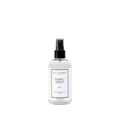 The Laundress spray frontal mostrando botella elegante y beneficio de frescura