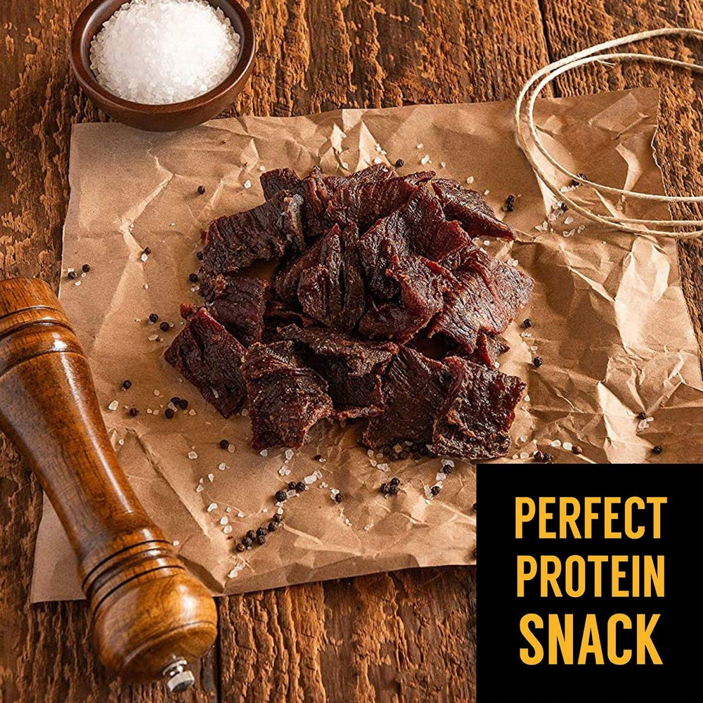 Tillamook Country Smoker jerky junto a una mano para mostrar tamaño práctico
