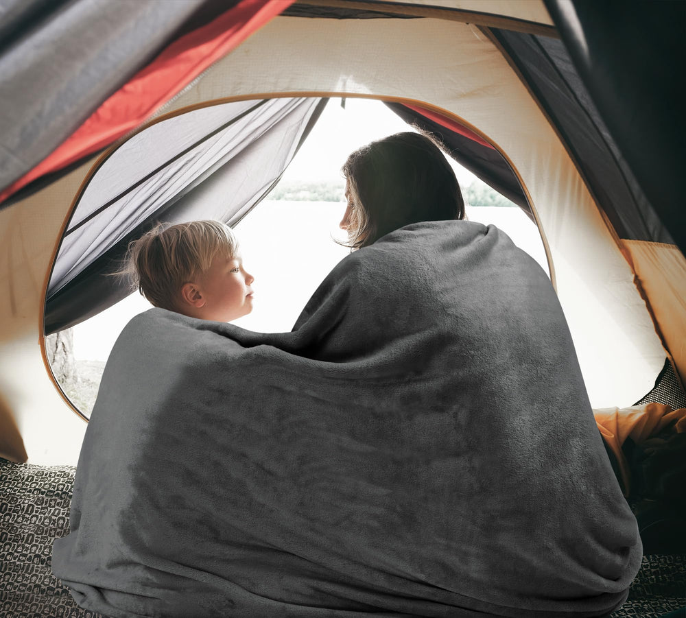 Utopia Bedding mano sosteniendo la manta para comparar tamaño y portabilidad