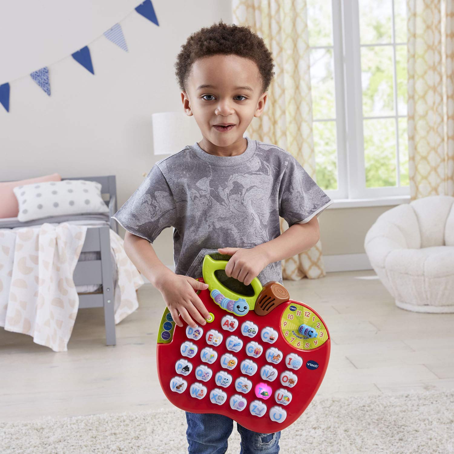 VTech ABC Learning Apple comparado con una mano para mostrar tamaño portable