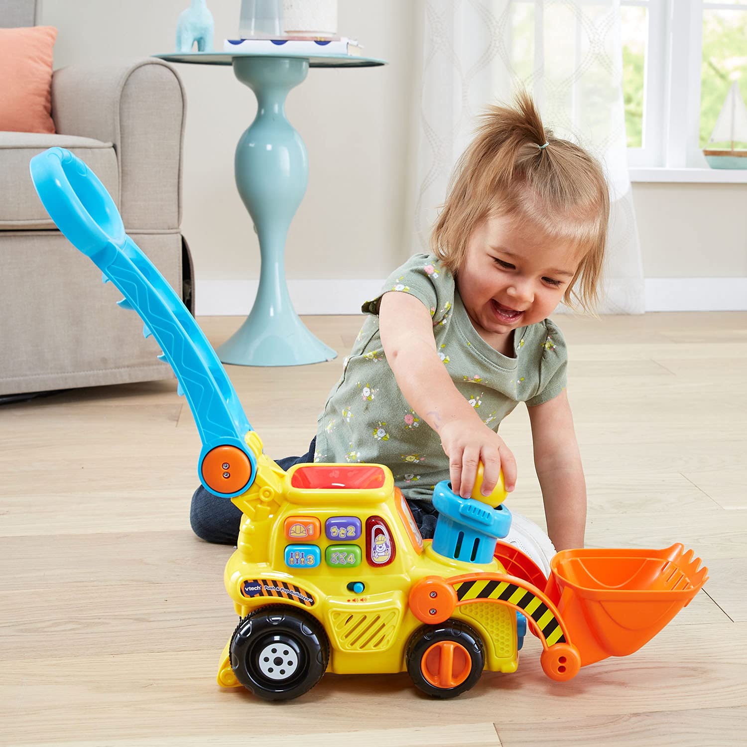 VTech bulldozer en salón con niño jugando, integra aprendizaje y familia