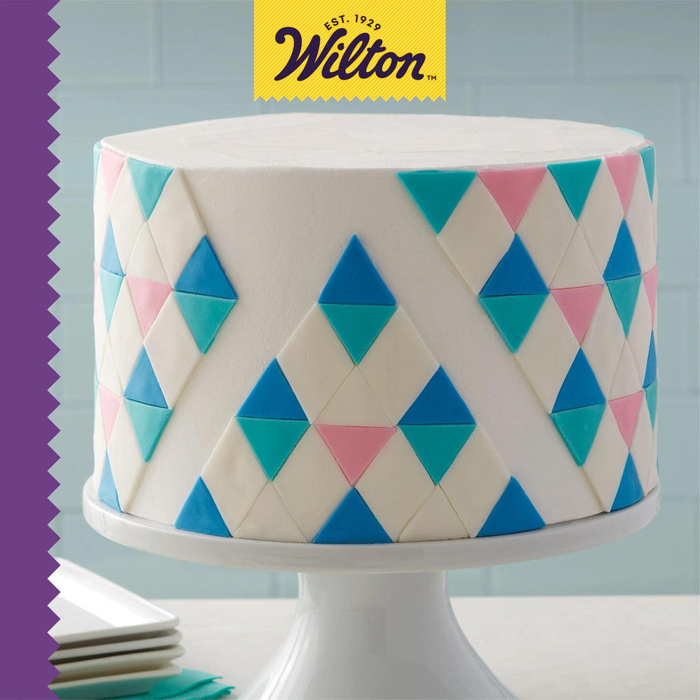 Wilton molde con papel y espátula mostrando preparación eficiente
