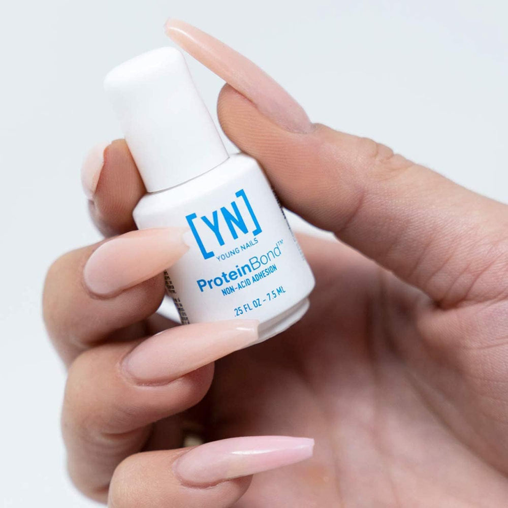 Young Nails Protein Bond en aplicación sobre uña con pincel, mejorando adherencia y acabado duradero